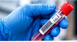 Gloved courier hand holding a labeled blood specimen tube